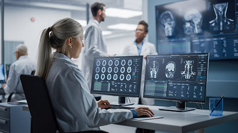 Portrait of Female Medical Scientist Using Computer with Brain Scan MRI Images