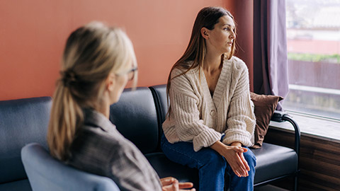 Sad frustrated woman talking in a session with a psychotherapist about her problems