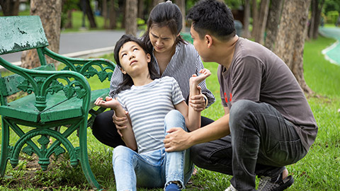 Sick little child girl with epileptic seizures in outdoor park