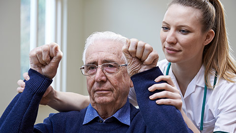 Nurse Assessing Stroke Victim By Raising Arms