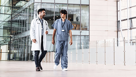 Two male medical staff walking at the corridor