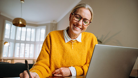 caucasian female working from home writing on documents