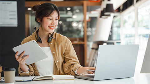 freelance looking and typing on notebook on table