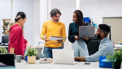 teamwork talking and using laptops in a modern bright office