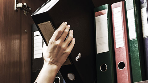 A person getting a file binder to record data