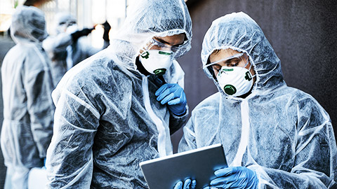 Healthcare workers wearing hazmat suits working together to control an outbreak