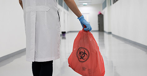 A person taking out biohazard waste periodically