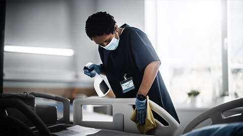 A person cleaning hospital equipment