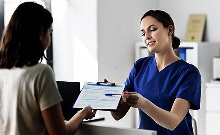 female doctor or nurse with clipboard and patient at hospital