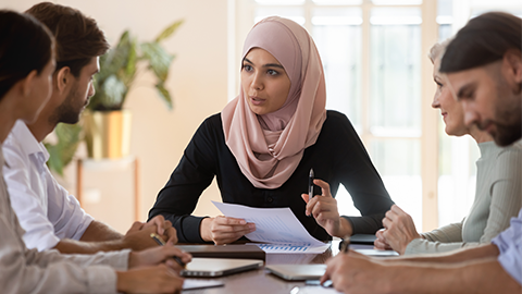 Confident Asian muslim female team leader holding corporate meeting