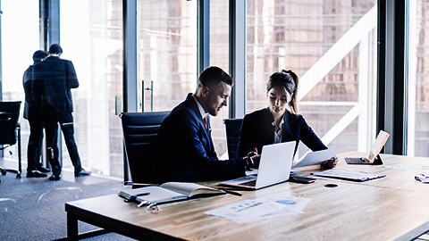 male and female business persons sitting at table having a consulting session