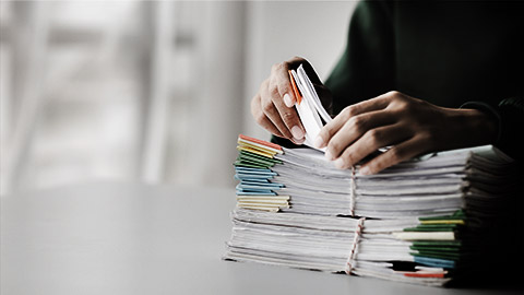 A person organising a pile of documents