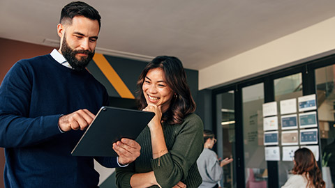 Happy business colleagues using a digital tablet in a boardroom