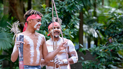 Happy Indigenous Australians men hunting in a rain forest