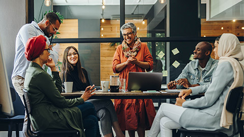 Happy businesspeople smiling cheerfully during a meeting in a creative office