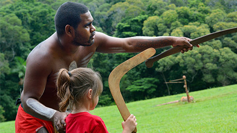 Australian Aboriginal warrior man teaching young Australian girl