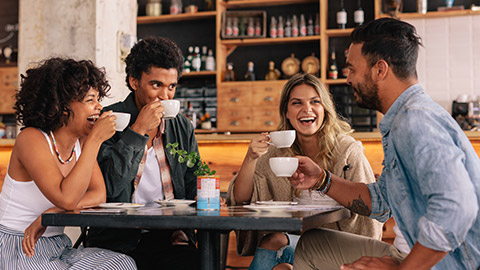 Diverse group of friends enjoying some coffee together in a restaurant and talking