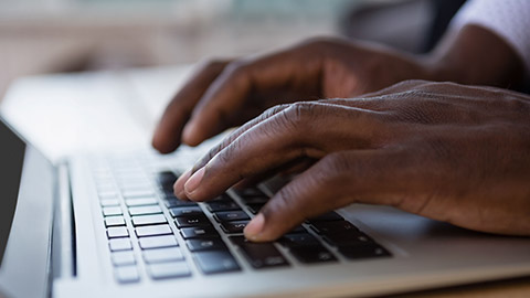 Close view of a person typing on a keyboard