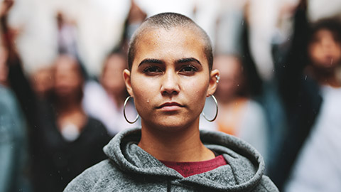 A single person at the front of a group of protesters