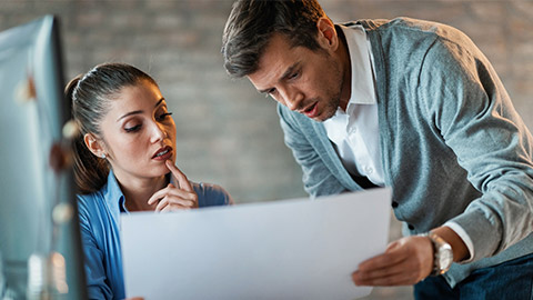 Two entrepreneurs cooperating while reading blueprints