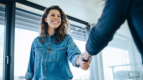 Recruitment manager shakes her hand with male candidate as he gets the jo