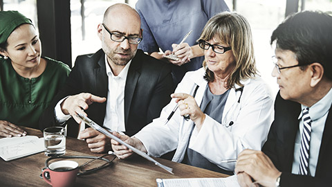 Group of medical people on discussion while looking at screen