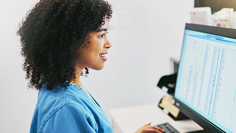 Nurse, computer and black woman typing for research in healthcare reports or telehealth.