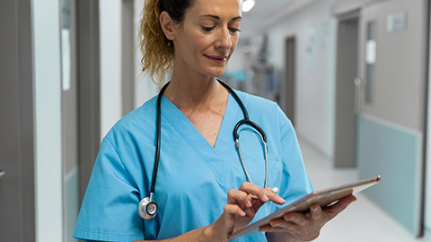 A nurse reading information on a laptop