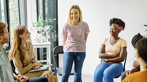 Group psychotherapy. Persons sitting in circle and talking.