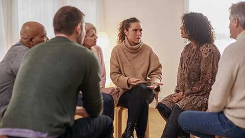 Woman Speaking At Support Group Meeting For Mental Health Or Dependency Issues In Community Space