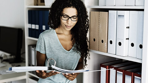 A person reading a folder of files