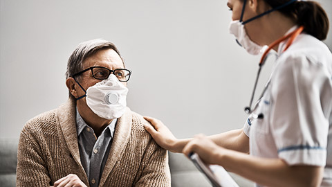 Doctor and senior man wearing facemasks during coronavirus and flu outbreak