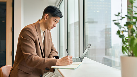 A person writing notes in an office