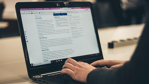 A person typing information on a laptop