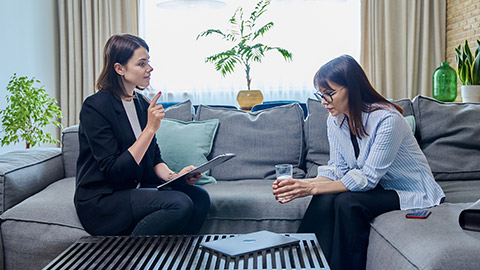 Female psychologist having therapy with middle-aged woman patient in office