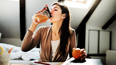 A person drinking orange juice for vitamin C