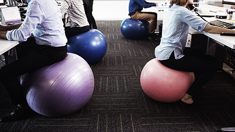 A group of employees sitting on yoga balls to be fit while working