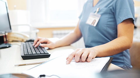 A close view of a person typing a report