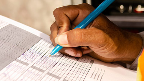 A close view of a person filling out a report