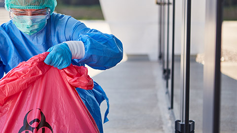 A person in PPE collecting hazardous materials