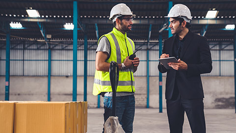 A manager talking to a worker in a factory