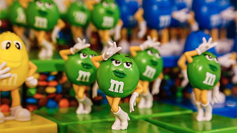 A close up of the green, yellow and blue M&Ms Mascots