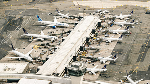 A series of grounded aircraft, all dotted around the wing of an airport terminal