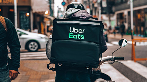 An Uber Eats Rider, about to mount their bicycle and deliver dinner to an Uber Eats Customer