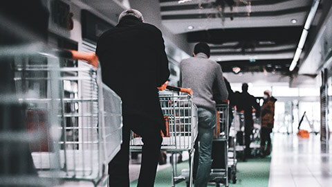 A queue of people waiting to get into a grocery store