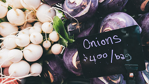 A close view of a market stall selling onions