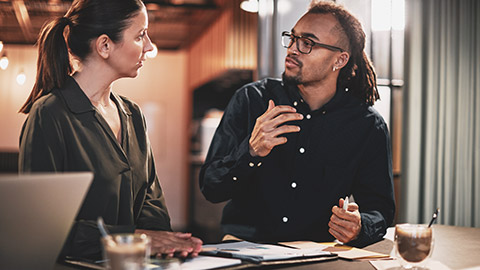 Two colleagues holding an animated conversation in their workplace