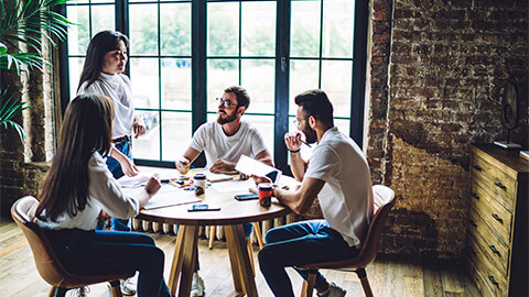 Colleagues holding a planning session around a table in a casual office