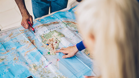 Two colleagues assessing a large map of the pacific