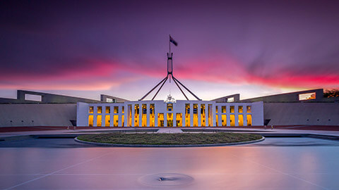 A wide shot of Parliament House at sunset